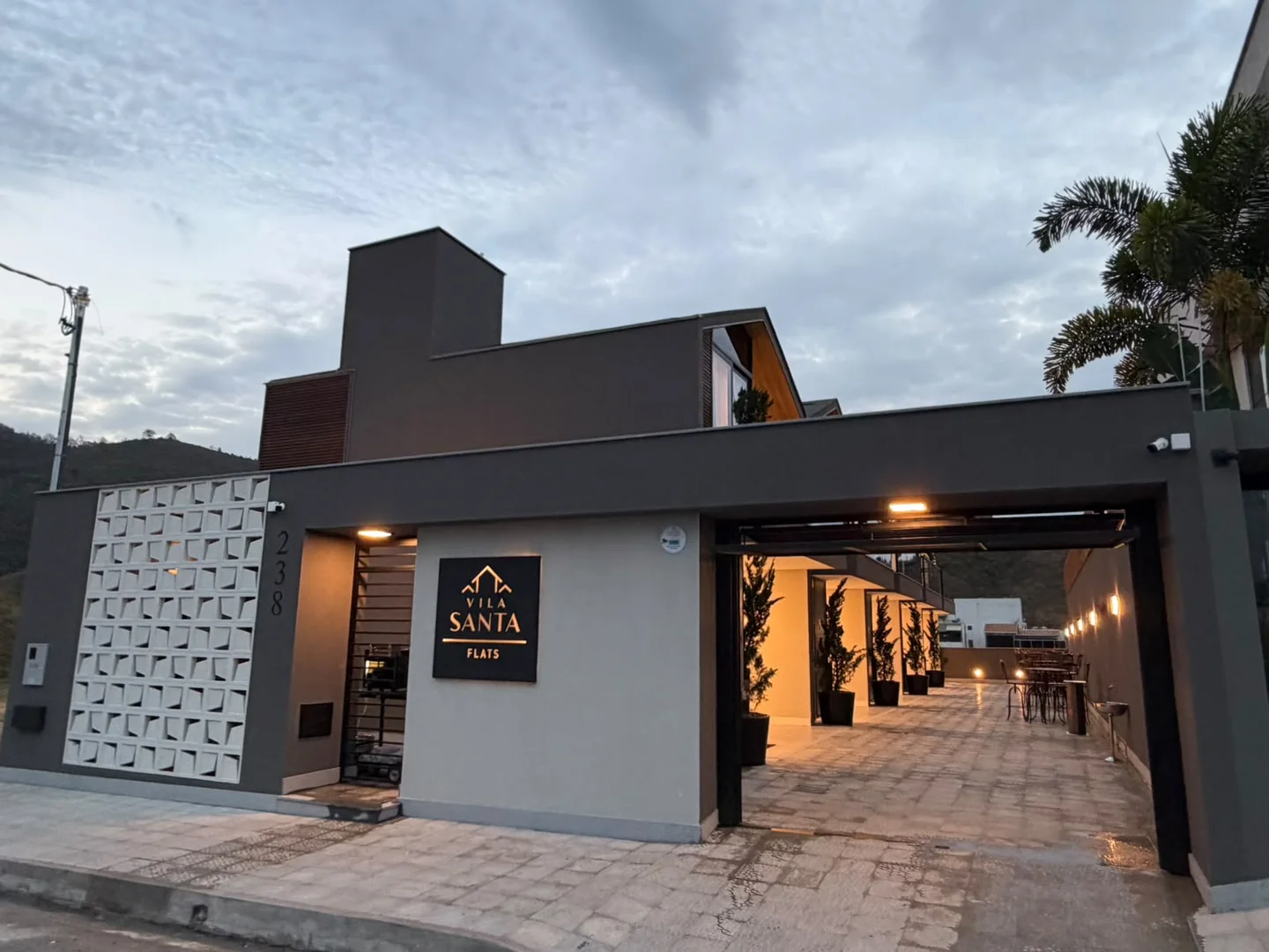 Entrada e garagem do condomínio Vila Santa Flats ao entardecer