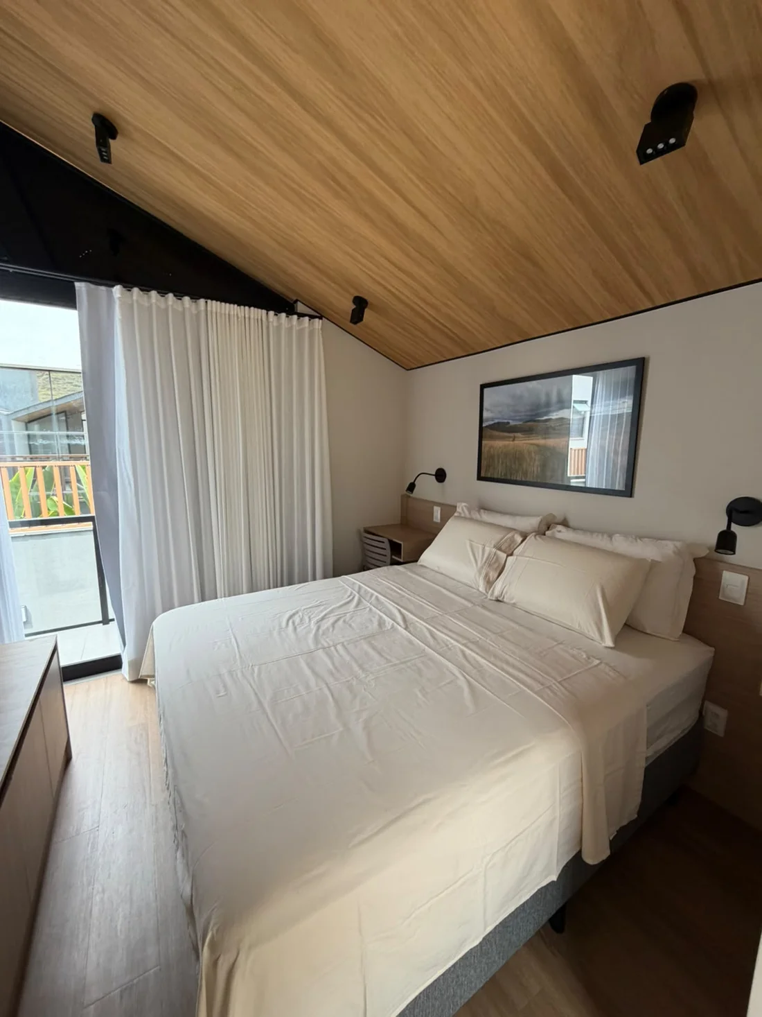 Quarto com cama de casal e acesso à varanda